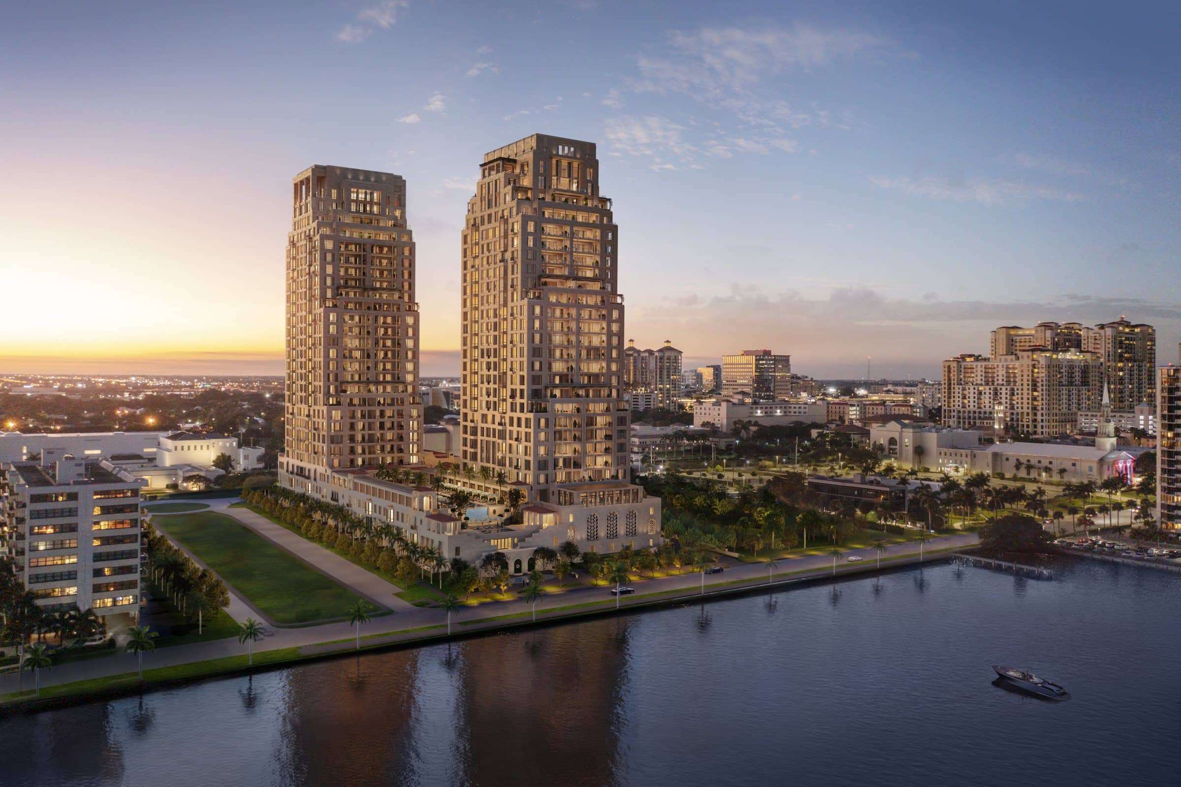 Rendering of two limestone residential towers on the West Palm Beach waterfront at dusk, above a lawn and a palm-lined promenade