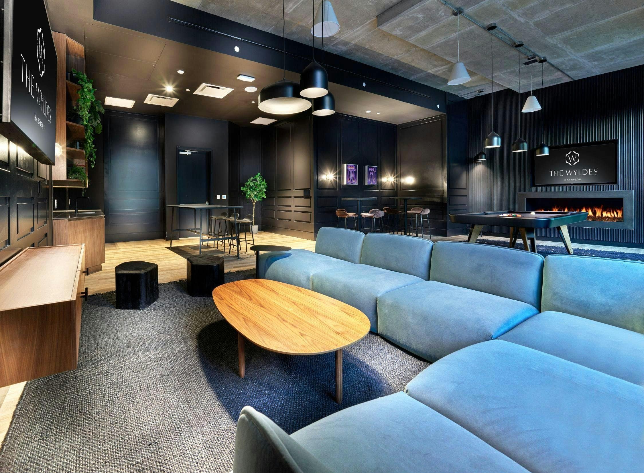 Two framed works are visible beyond the sofas in The Wyldes clubroom.
