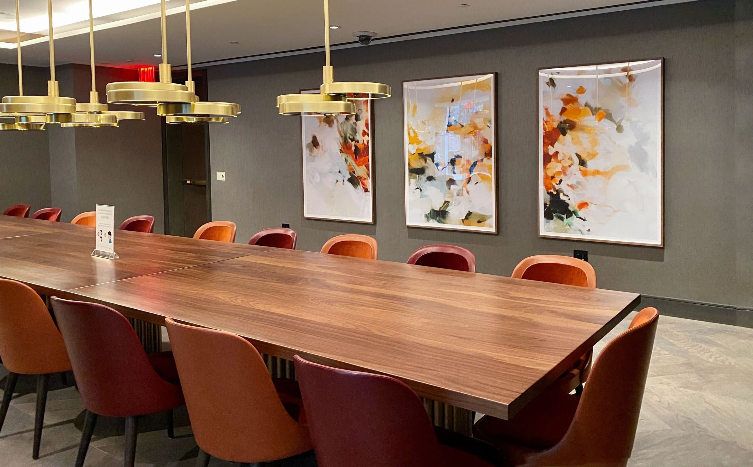 Three framed abstract prints hang above a long dining table at Lantern House.