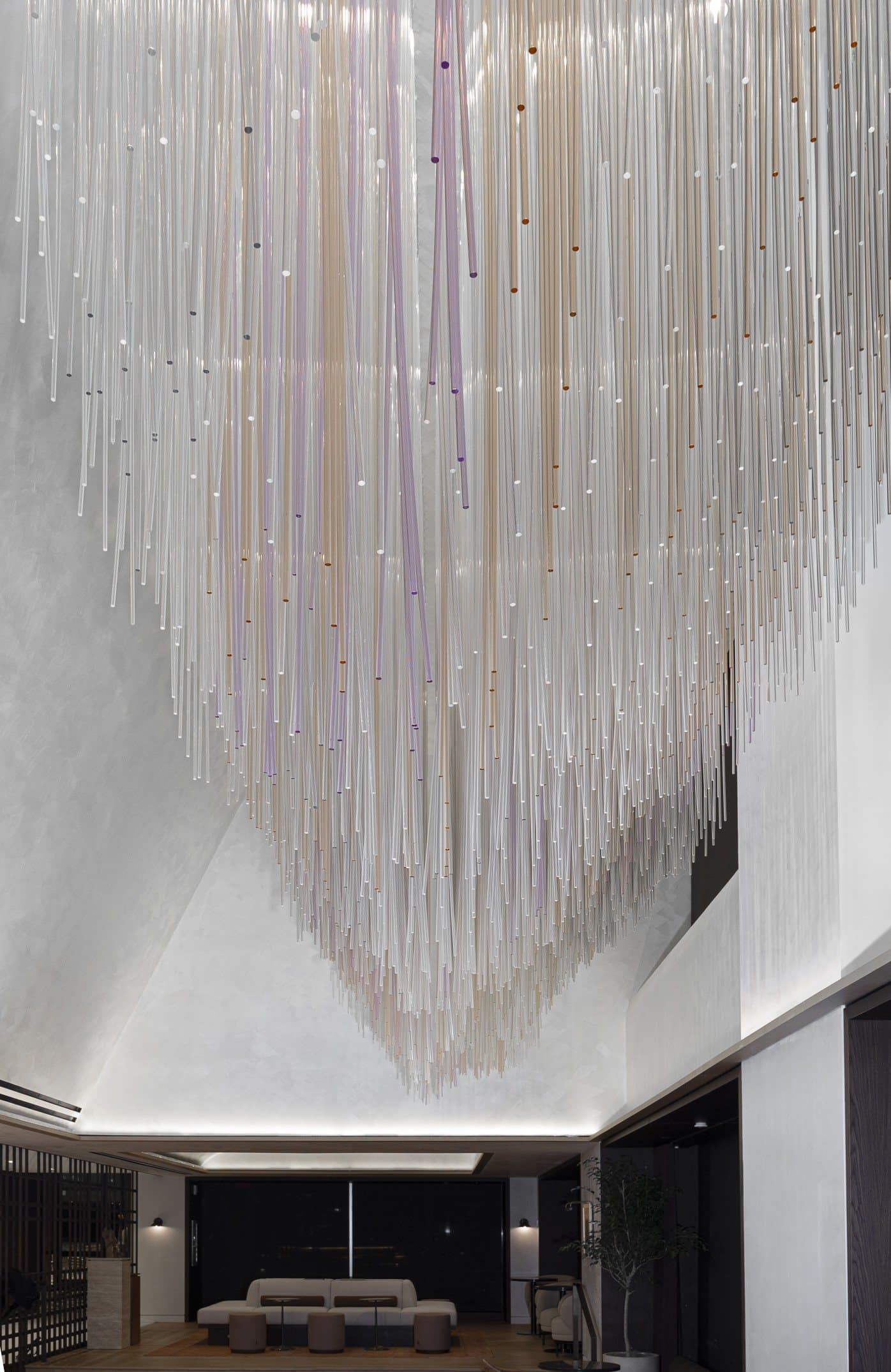 Long suspended rods form a rippling lower edge above the seating area at the far end of the atrium