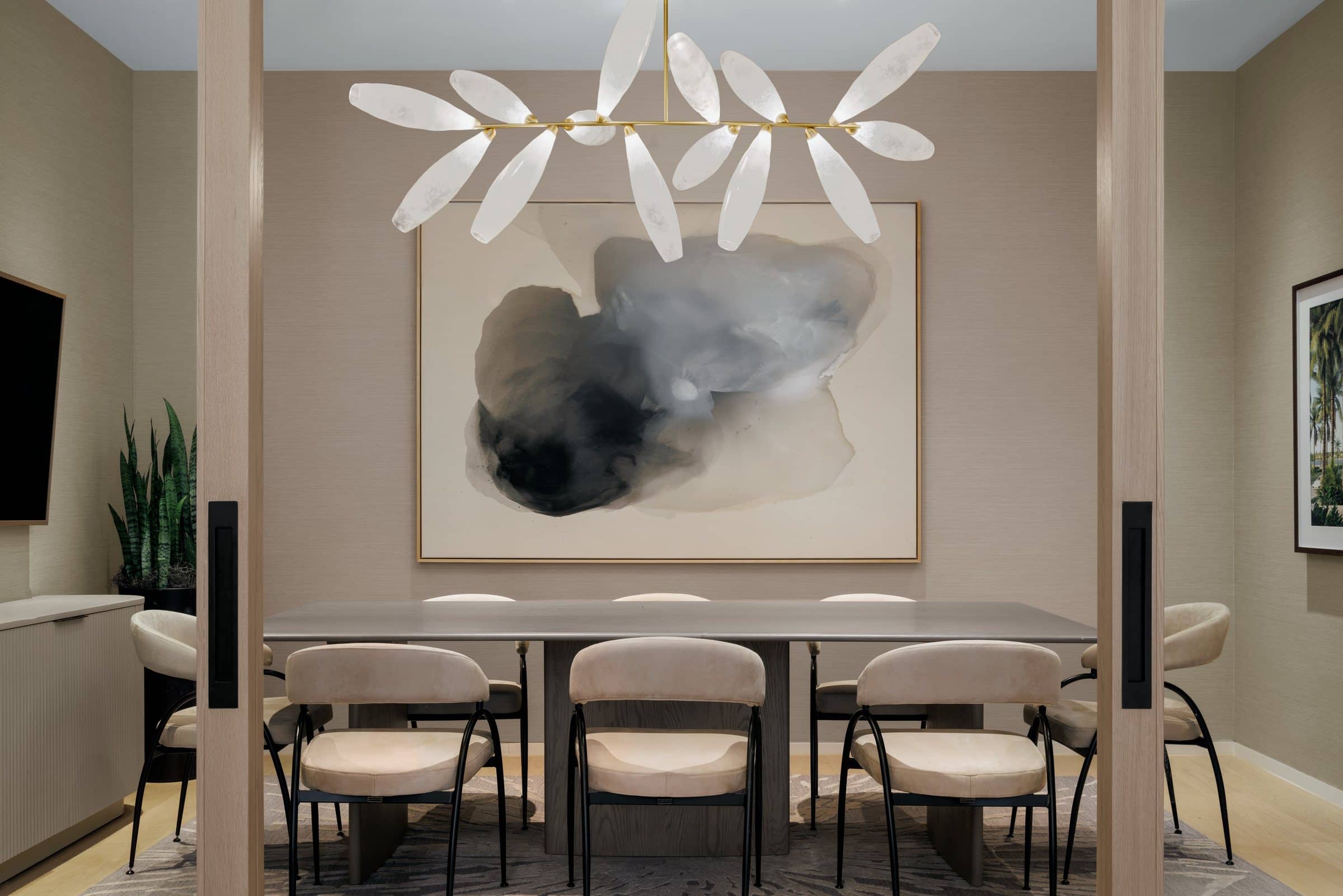 Conference table beneath a large black, gray and pale blue cloud-like abstract on cream