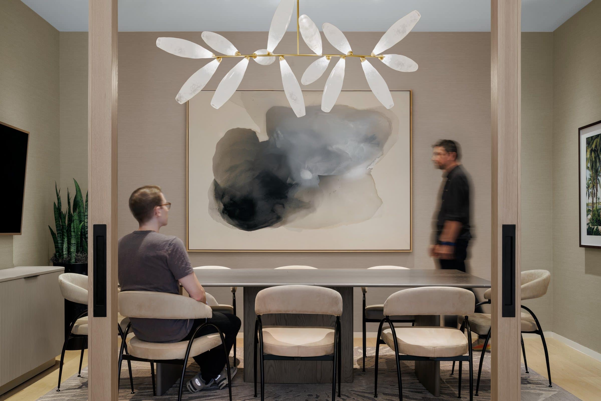 Two visitors give scale to the large cloud-like abstract behind the conference table