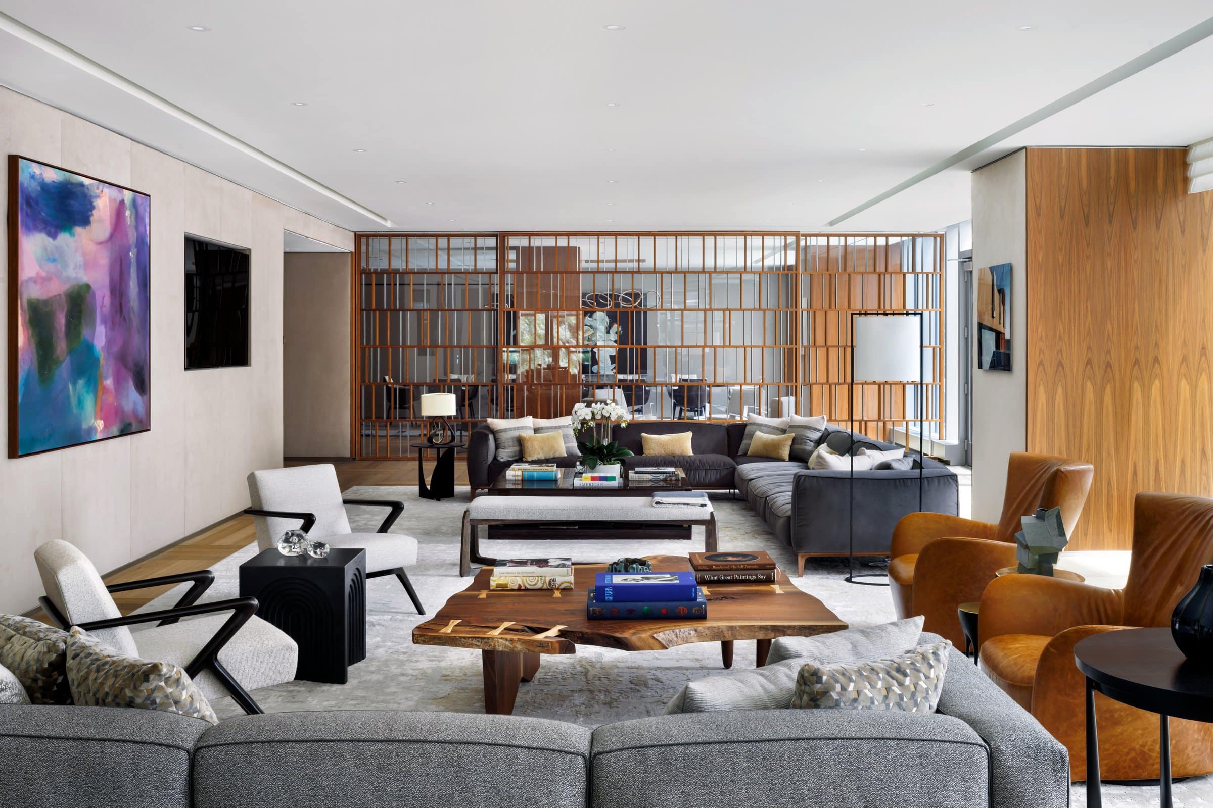 Lounge with gray sofas and a live-edge table, with a purple, blue and pink abstract beside the television