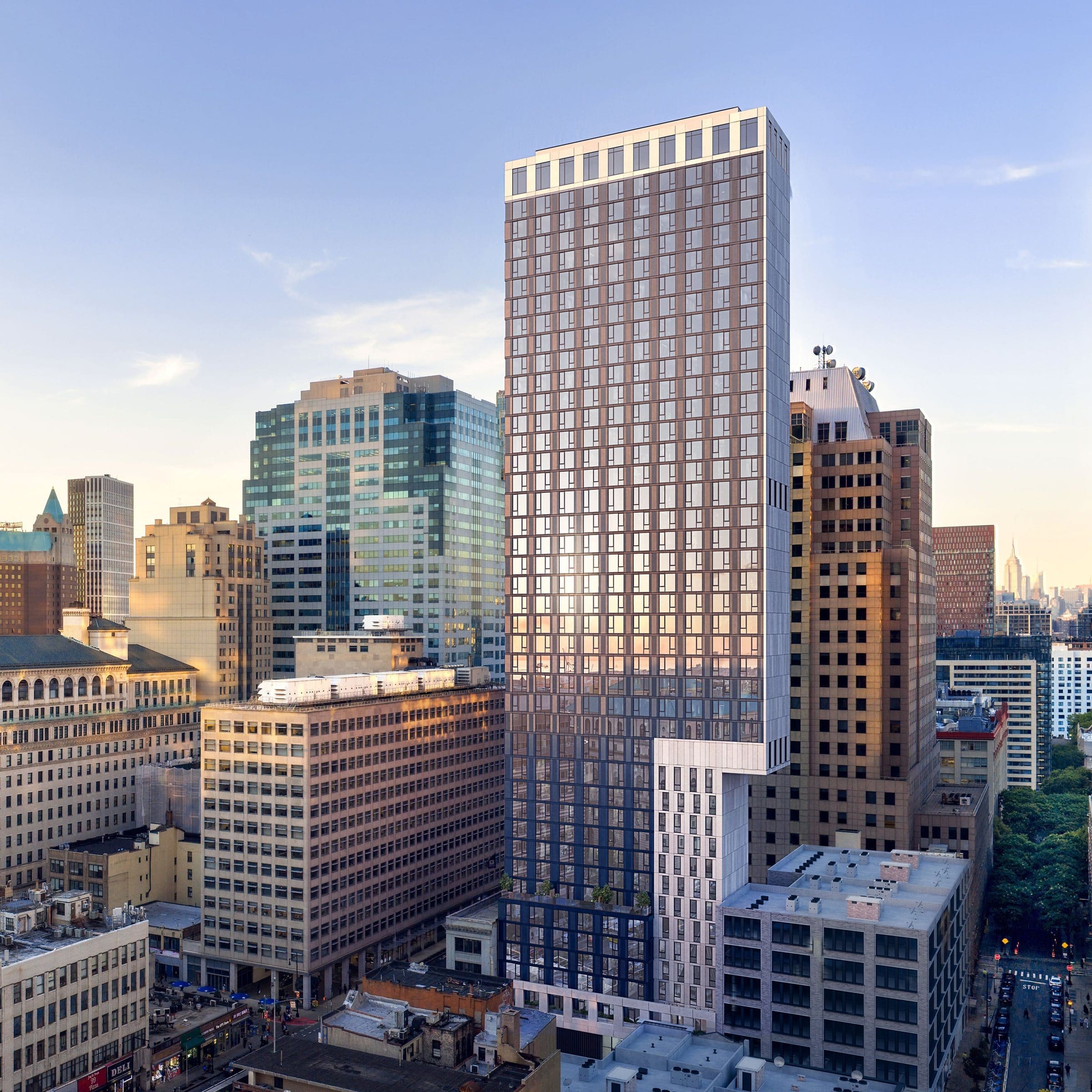 Rendering of a slender residential tower rising above the office buildings of Downtown Brooklyn, with the Manhattan skyline in the distance