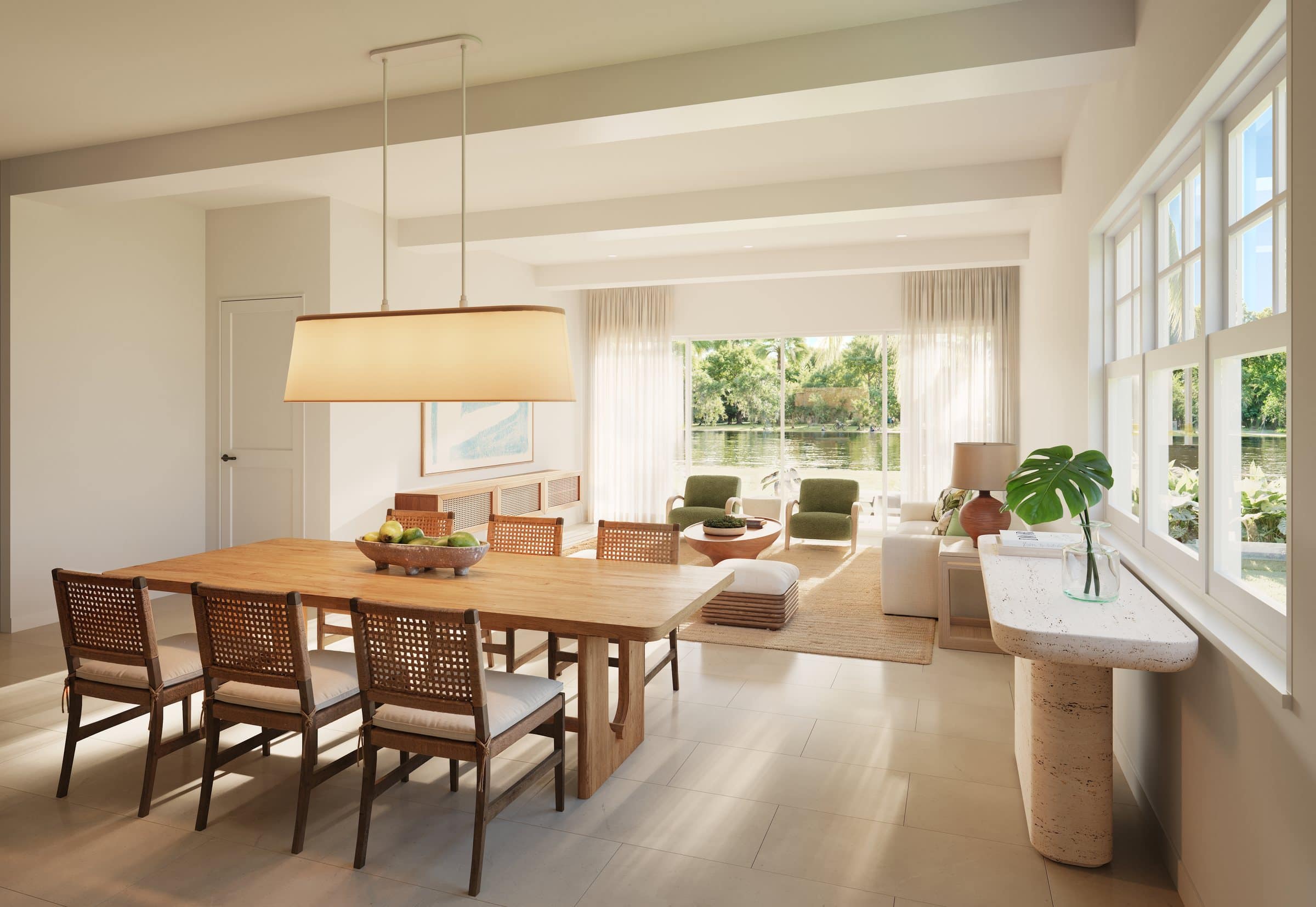 Rendering of a bright villa dining room with a long wooden table, woven chairs and a large pendant lamp, opening to the living room