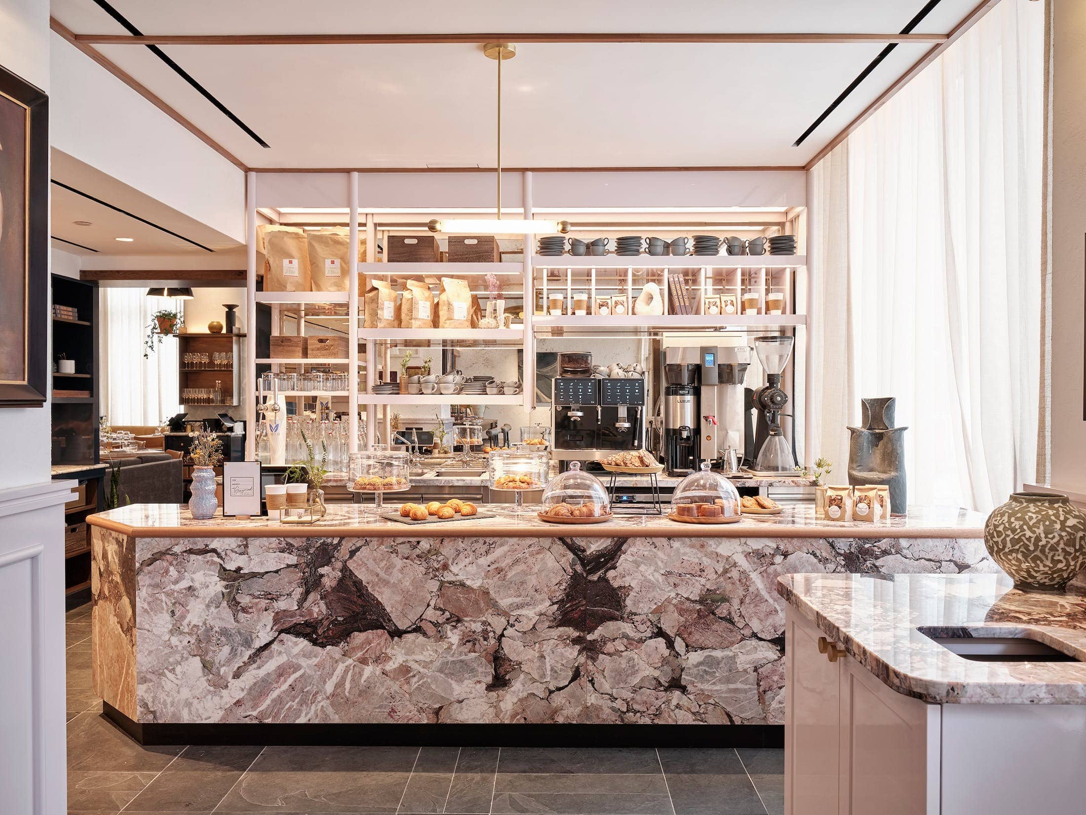 Greywind bakery counter with a marble island and shelves behind
