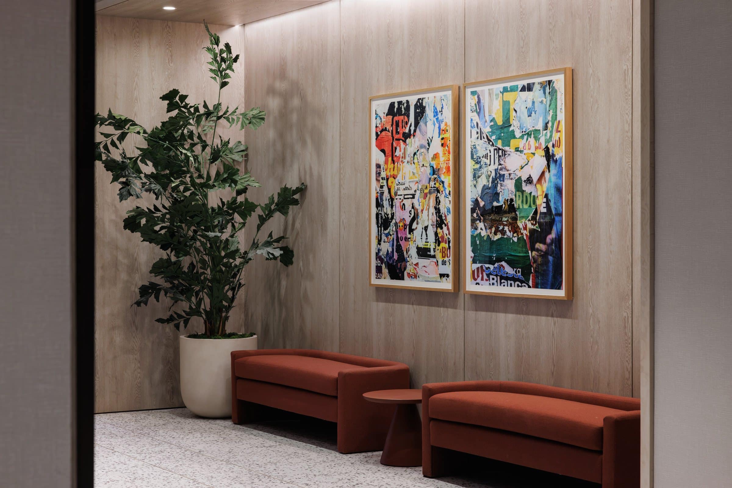 Two framed torn-poster collages above red benches against a wood-paneled wall