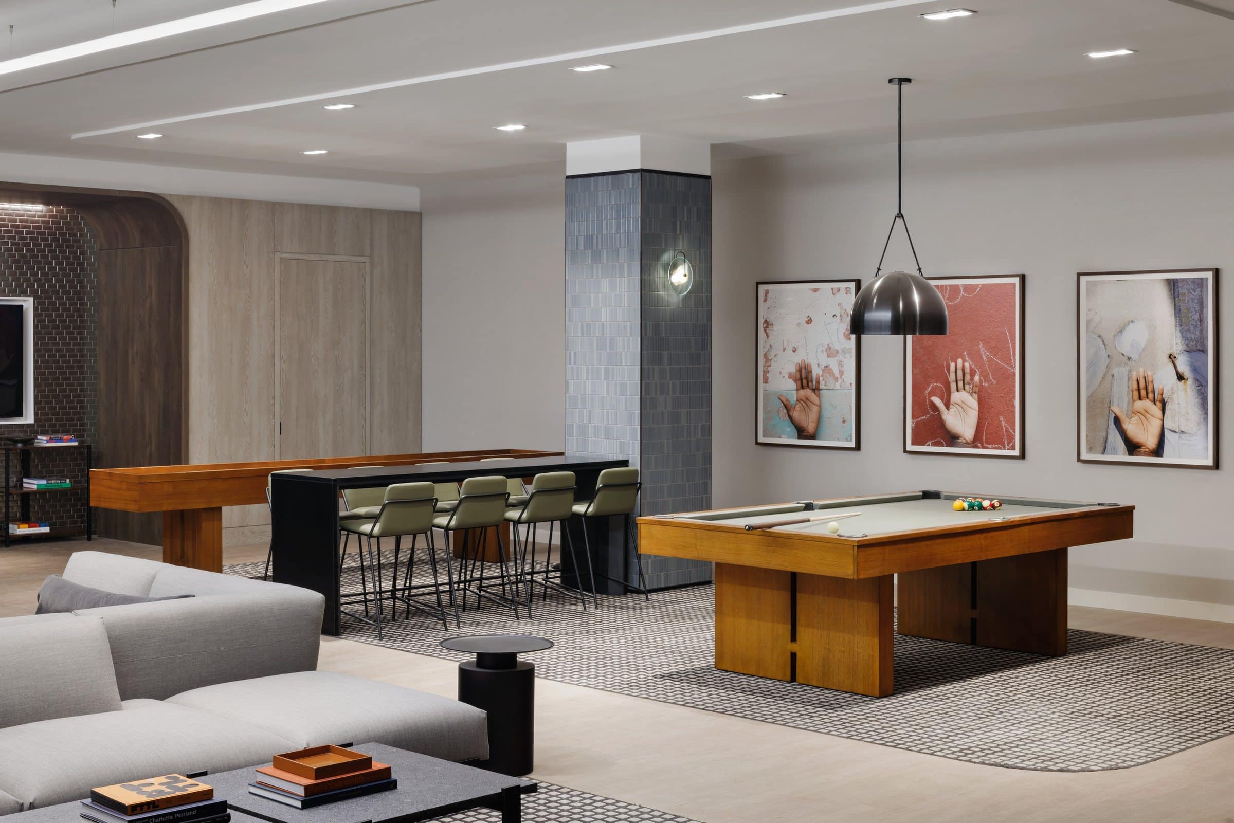 Games lounge with a pool table and three photographs of raised hands against marked surfaces