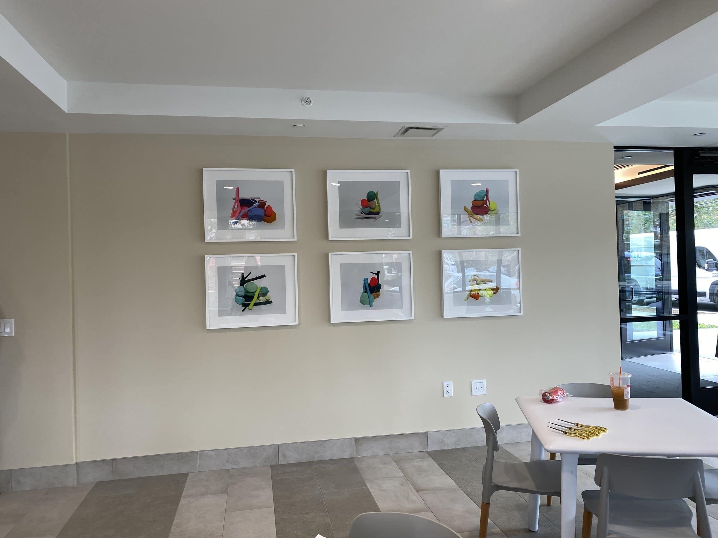Six framed colorful still-life prints hang in two rows at Harriet Tubman Supportive Housing Building.