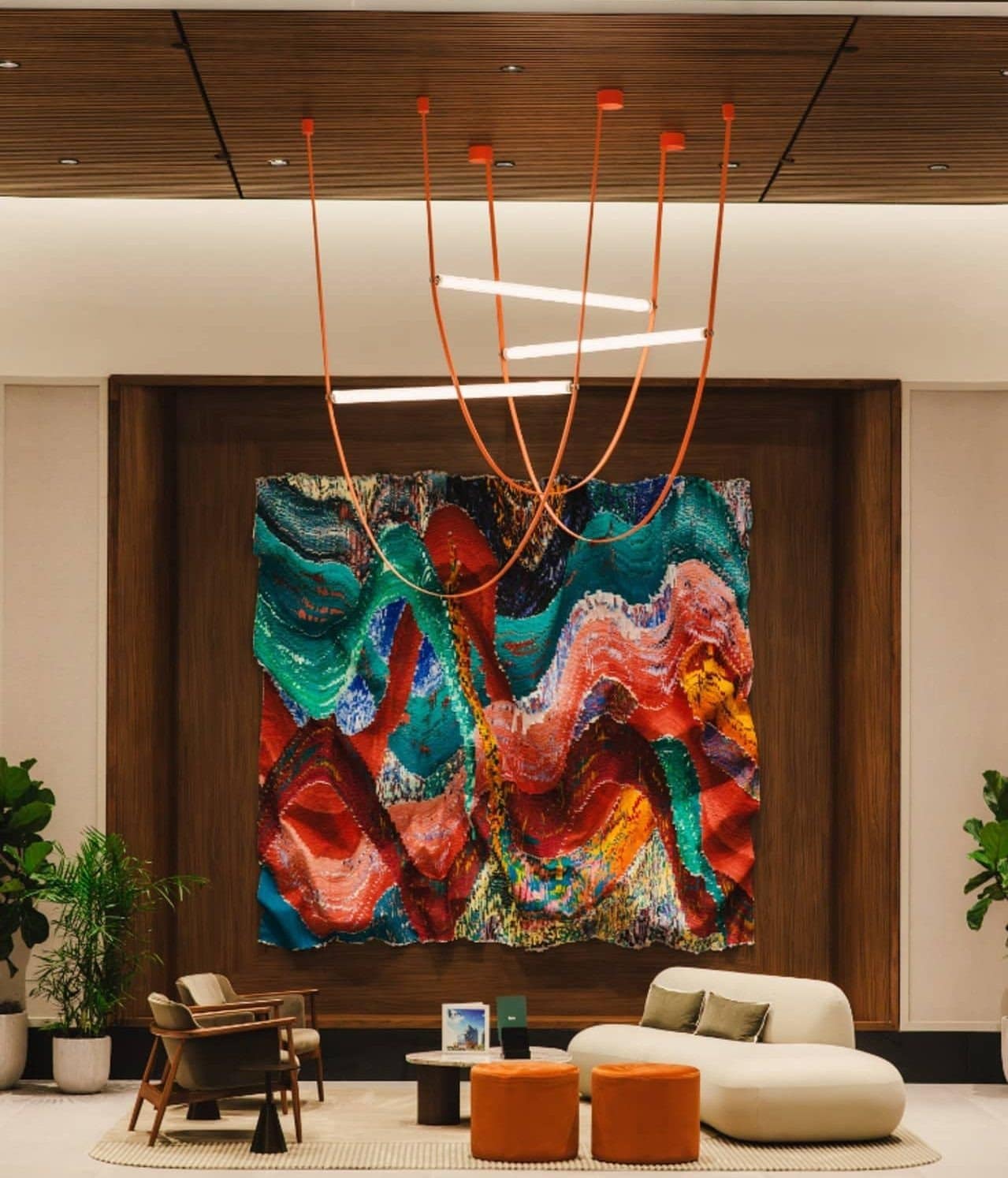 A closer view of the red, turquoise and pink silk commission above lobby seating at Linea.