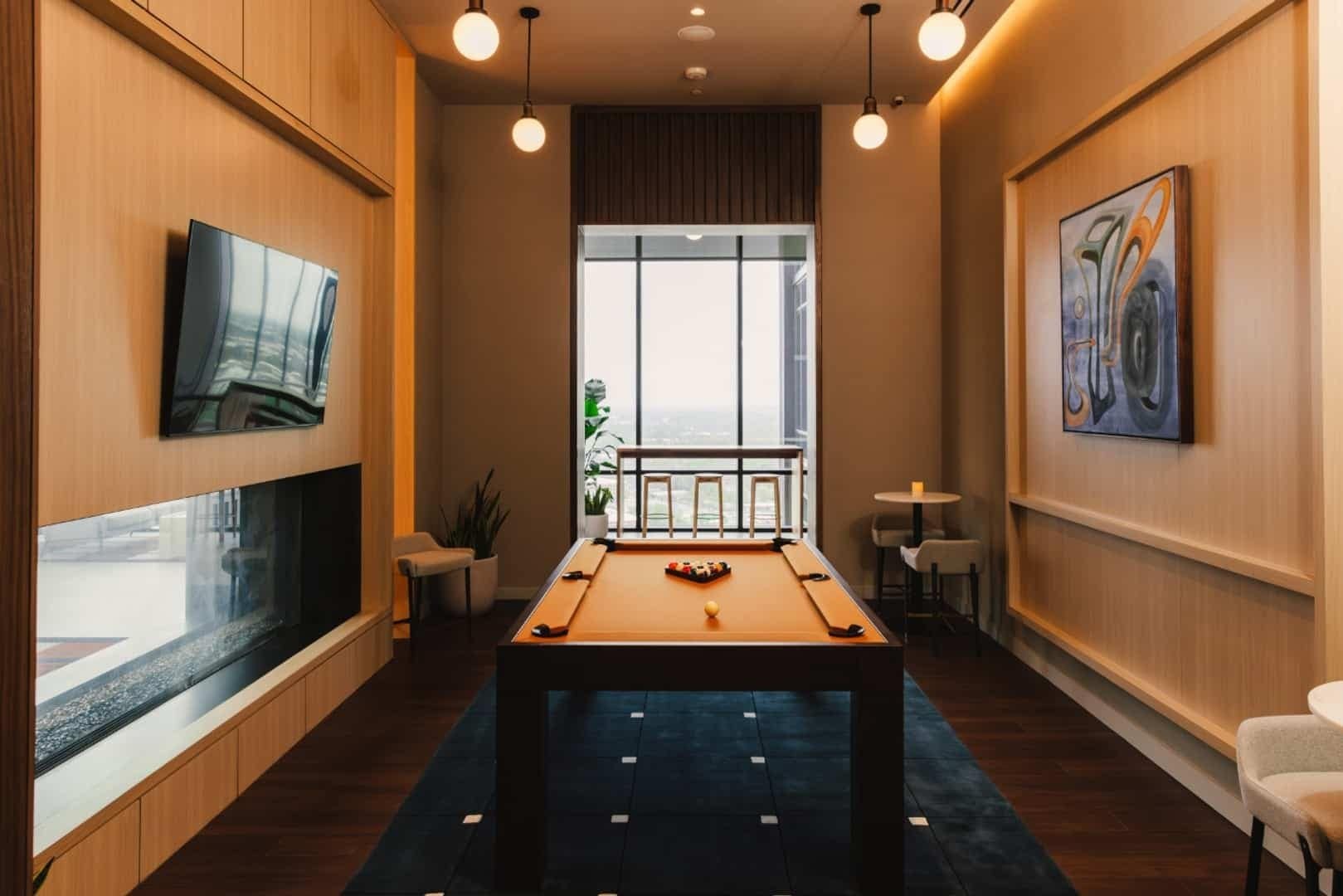 A painting of curved blue and orange forms hangs beside a billiards table at Linea.