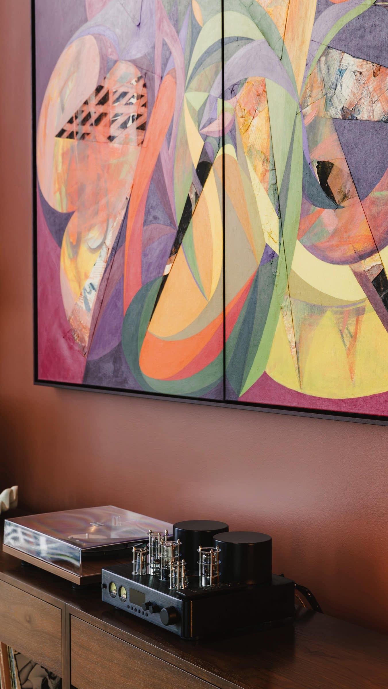 A close view of overlapping shapes and collage textures above the listening-room console at Linea.