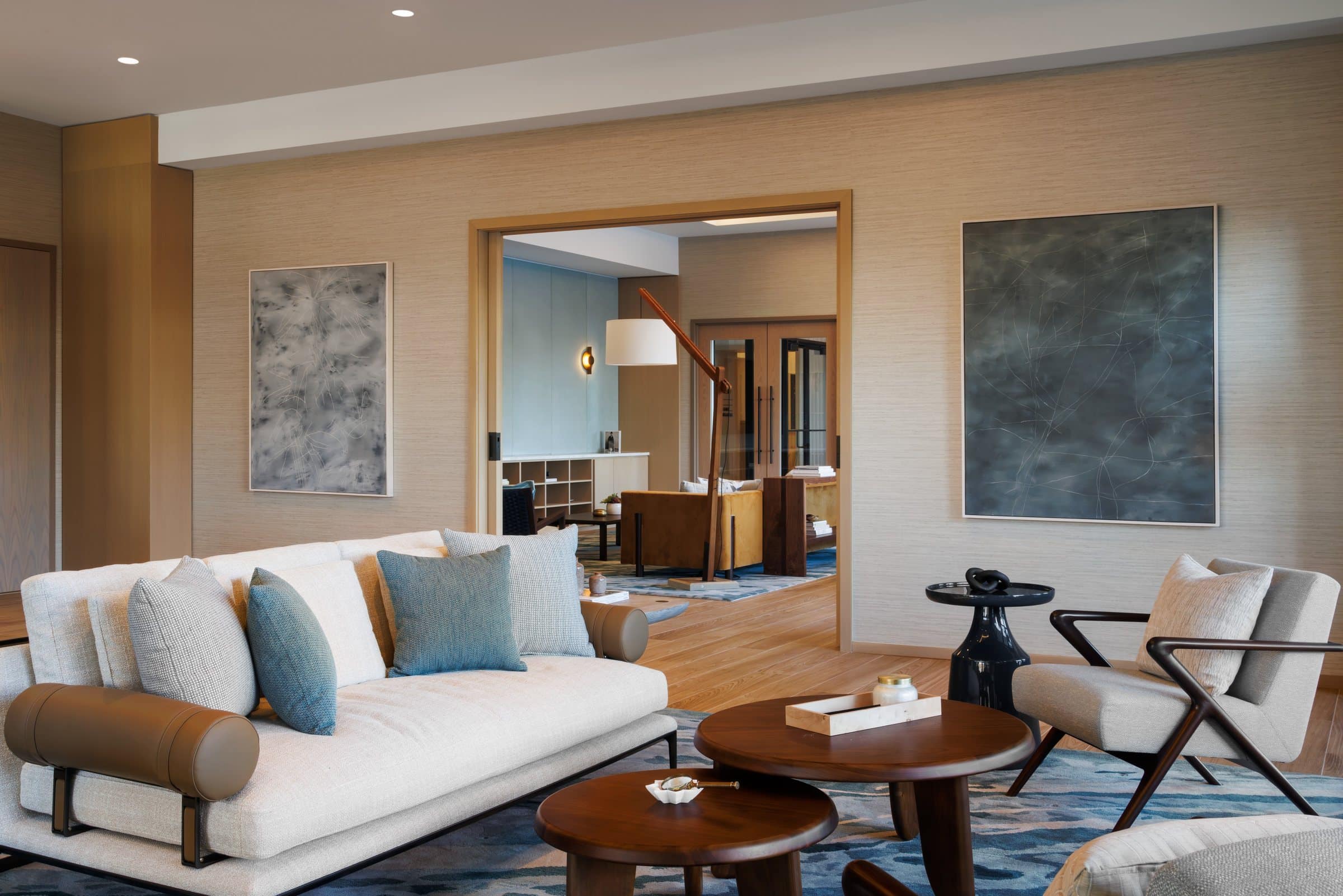 A pale gray painting and a dark green-gray painting with fine white lines flank a doorway in the lounge